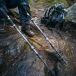 Baton de randonnee aluminium et carbone sur sentier humide, terrain montagne